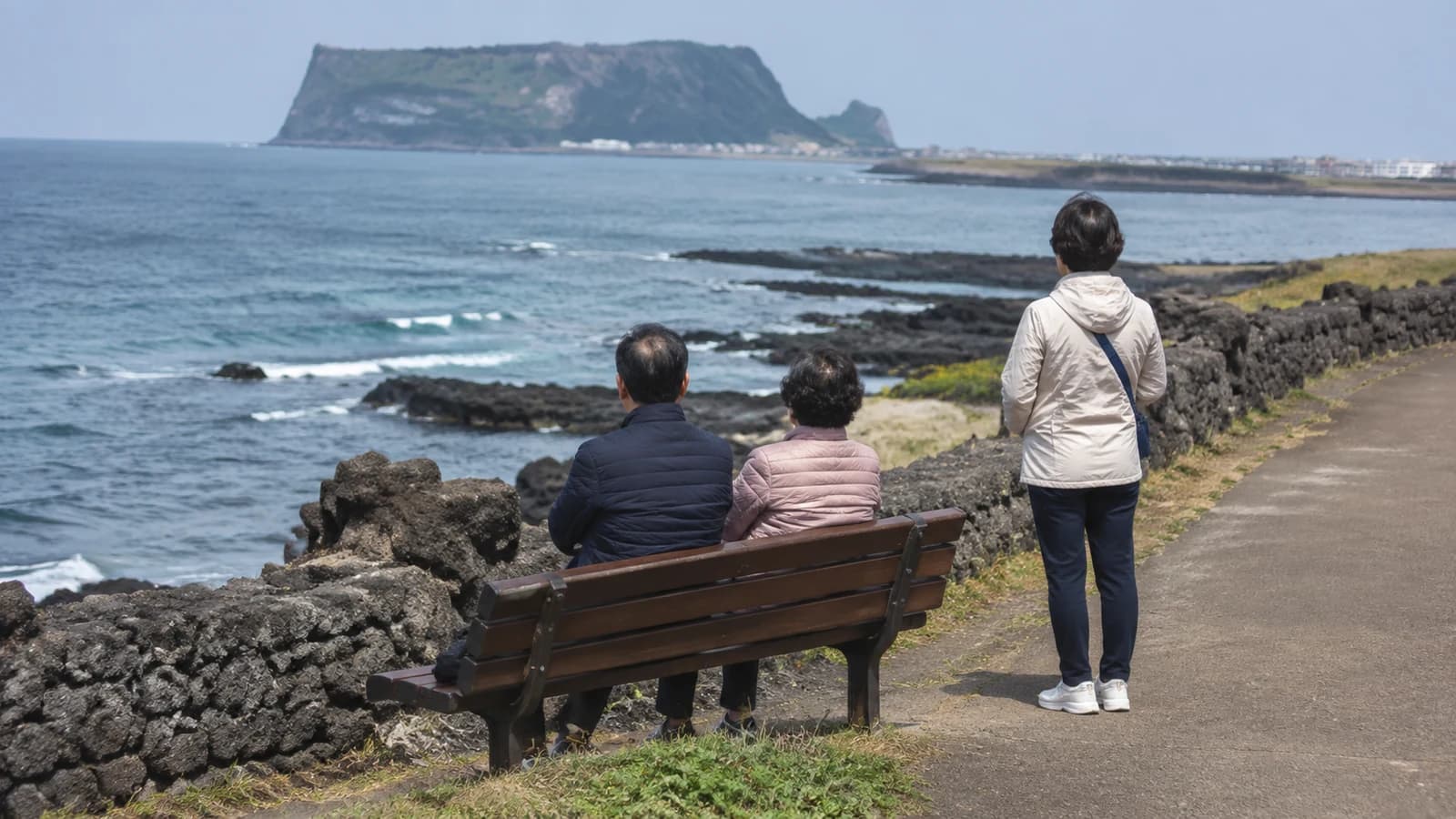 제주효도여행가격을 준비하는 부모님과 성인 자녀가 수국 핀 동부 해안을 걷는 먼 뒷모습